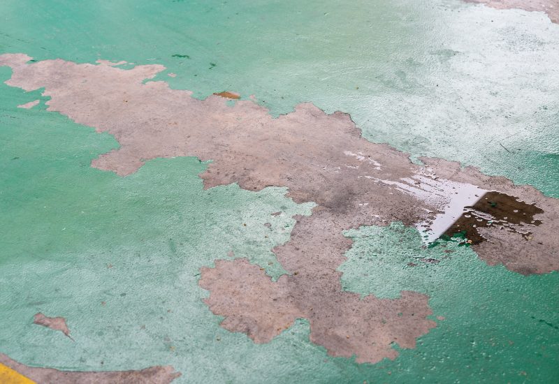 Worker Repairing a Worn-Out Epoxy Floor Coating in Jacksonville & St. Augustine