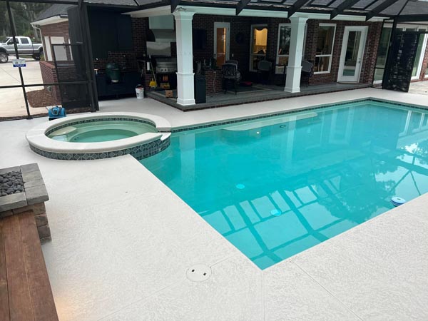 Residential pool and hot tub with light concrete decking in Jacksonville