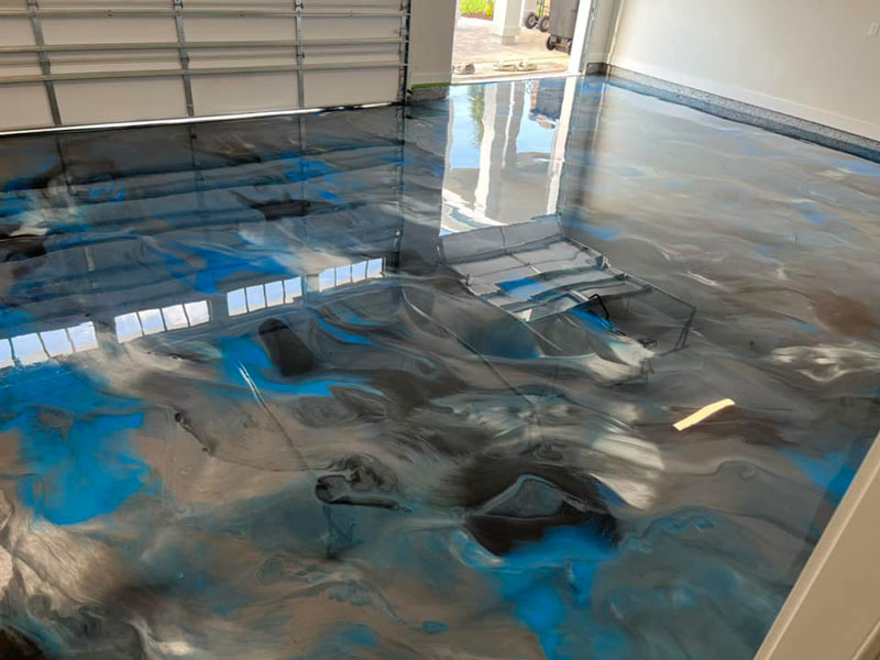 A metallic epoxy garage floor with a blue and gray swirl finish by Custom Floor Coating